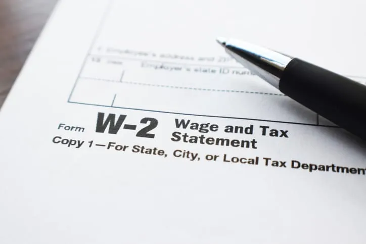 Close-up of an IRS Form W-2 Wage and Tax Statement with a pen